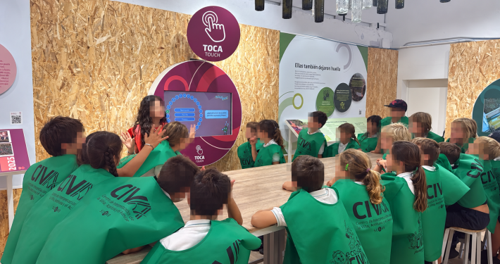 Escolares tocan una pantalla interactiva sobre el aceite de orujo de oliva en el museo interactivo del CIVA