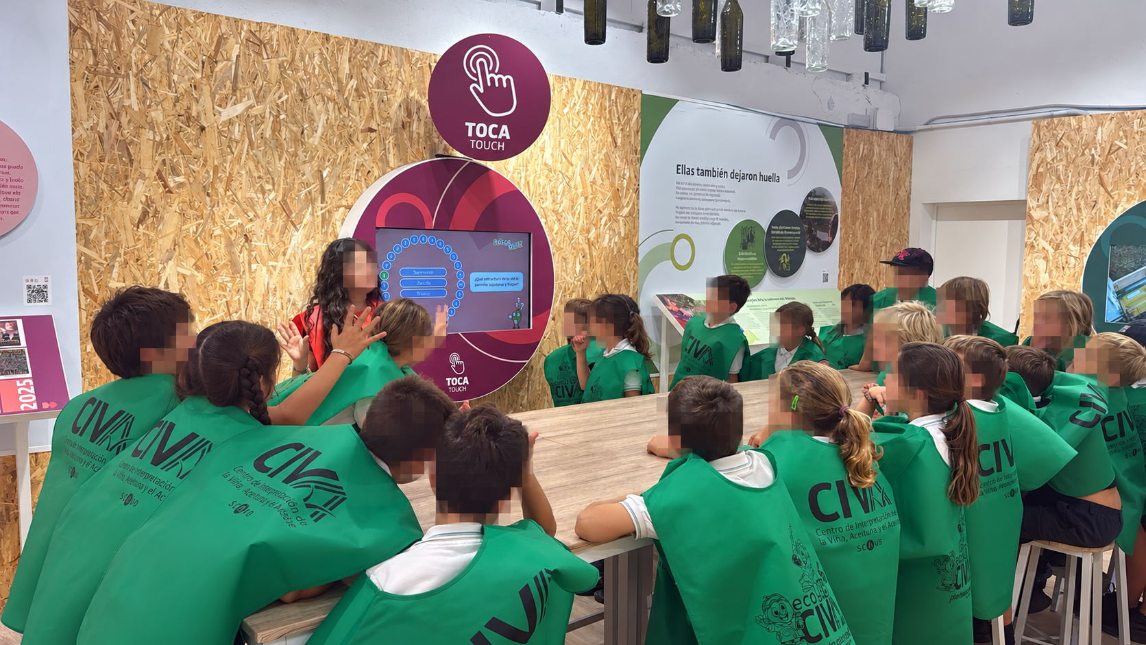 Visita escolar al museo interactivo Escolares tocan una pantalla interactiva sobre el aceite de orujo de oliva en el museo interactivo del CIVA